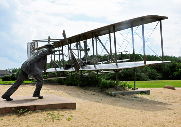 Wilbur Wright as he stradled the wing